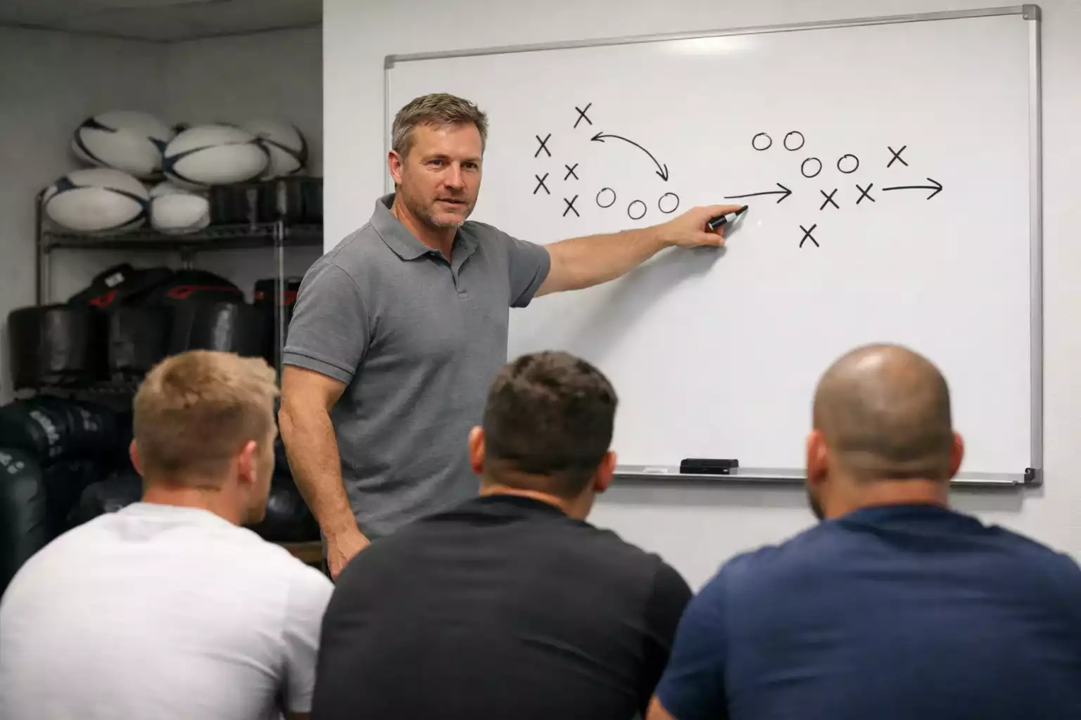 Rugby coach explaining tactics on a whiteboard to players